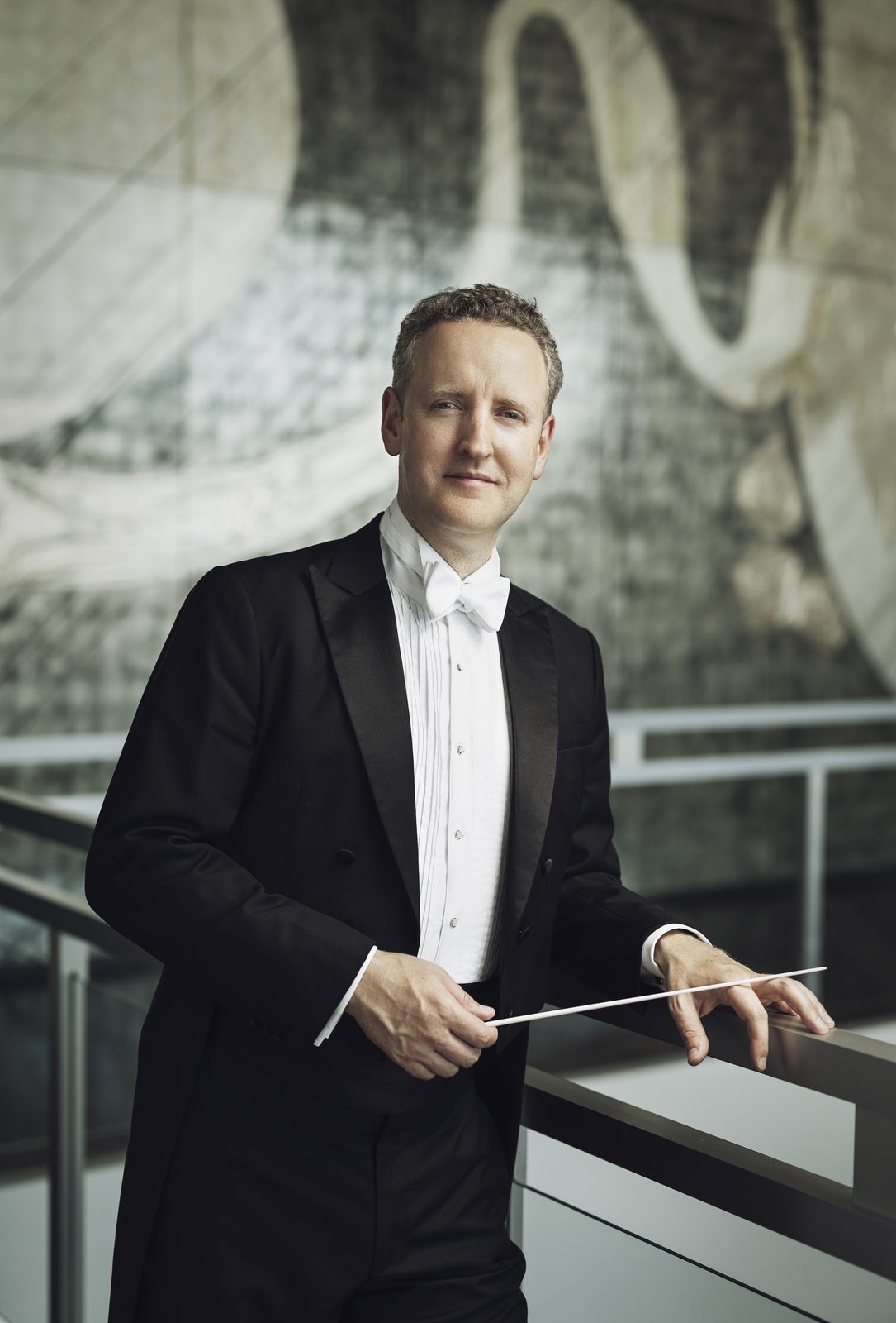 Michael Francis in white tie and tails with a baton